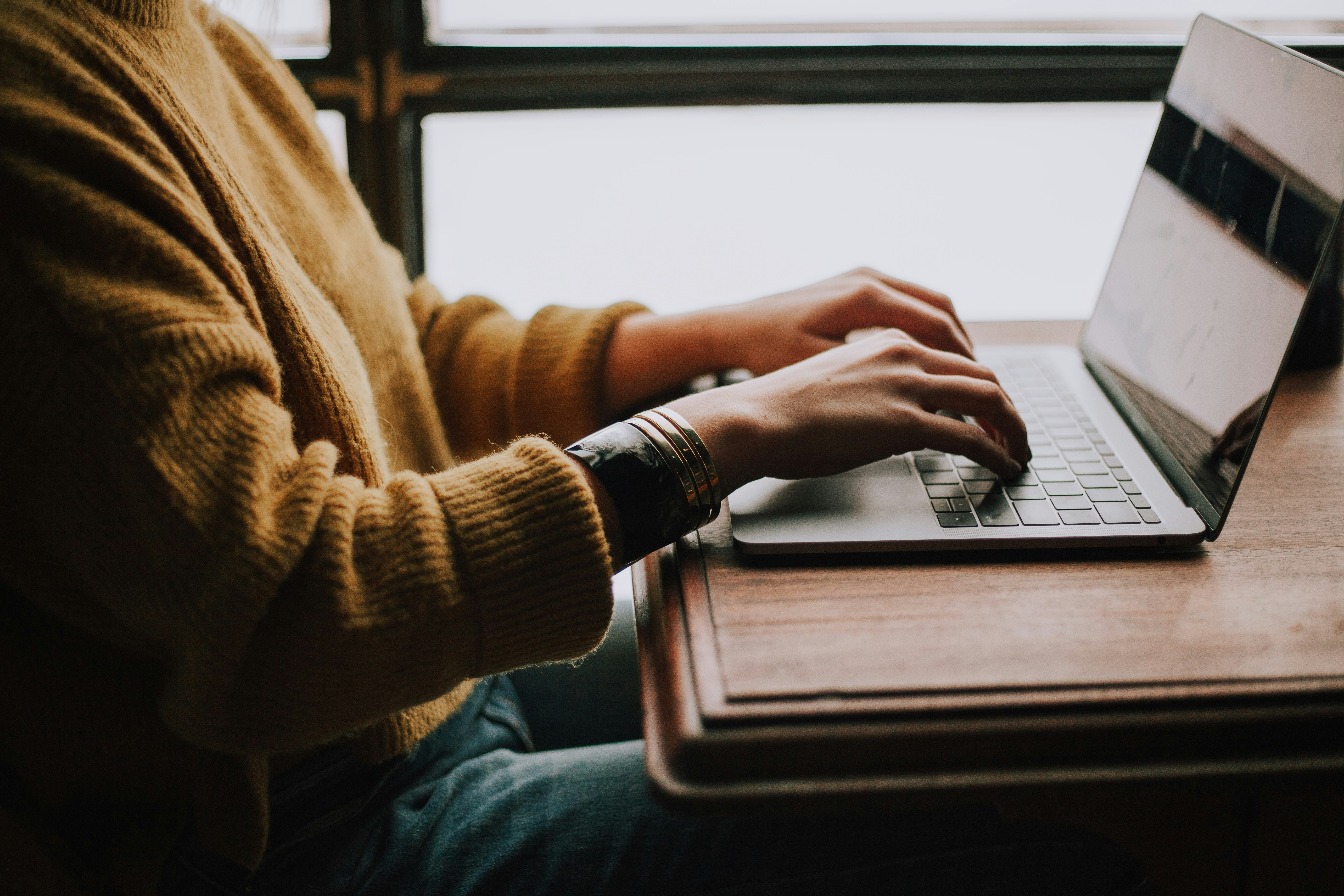 Person using a laptop at a desk, representing ADHD time management apps in use.